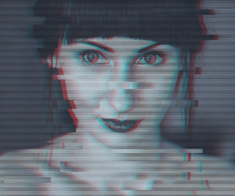 A close-up black and white image of a woman looking at the camera. There is a filter overlay that makes it look as if she is glitching