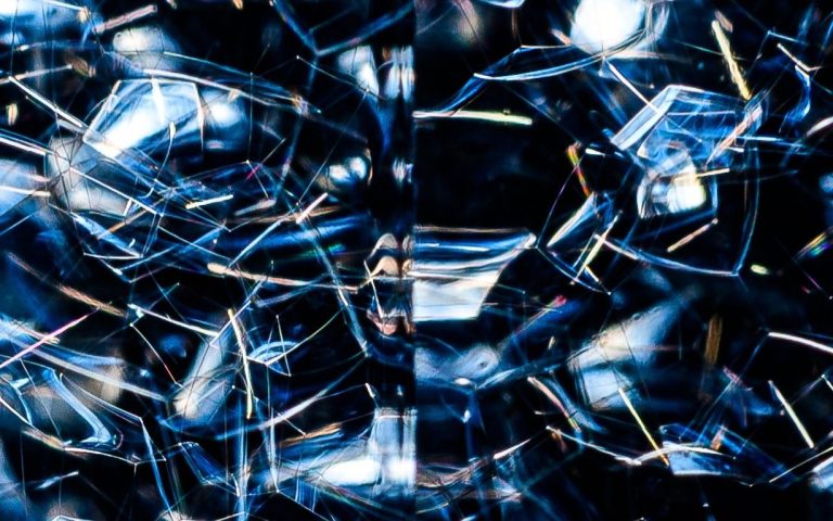 An abstract image of bits of glass overlapping each other on a dark background
