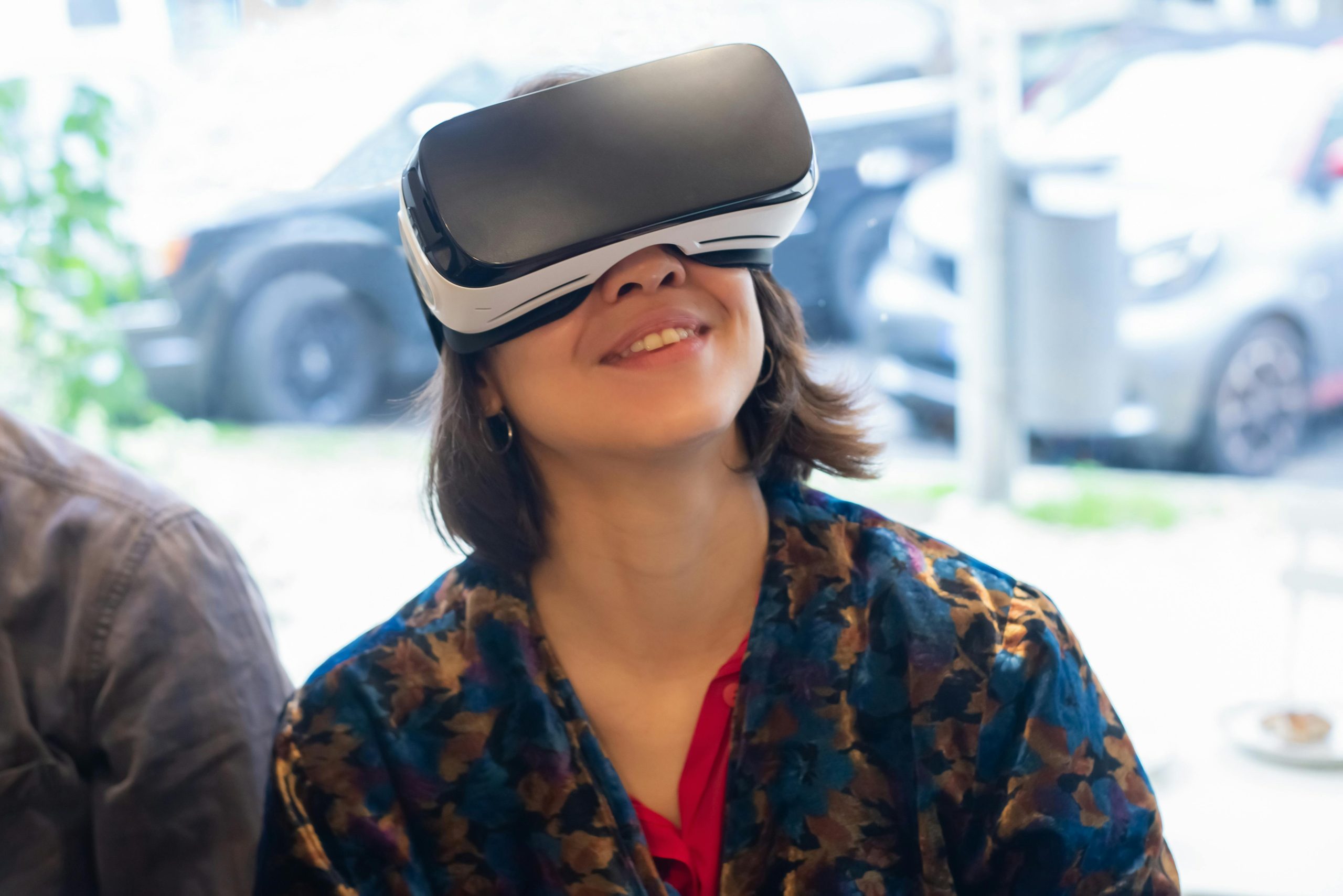 Extreme close up side on image of a person wearing Apple's Vision Pro headset. They are pressing a button on the top of the headset